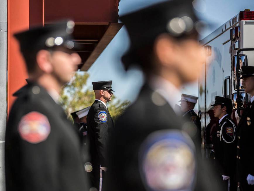 Henderson Fire and Police Department personnel wait to escort the cremated remains of Henderson ...