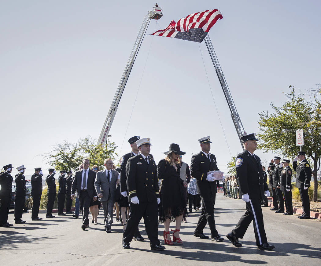 Henderson Fire Captain Garrett Dodrill, second from right, holds the urn containing the cremate ...