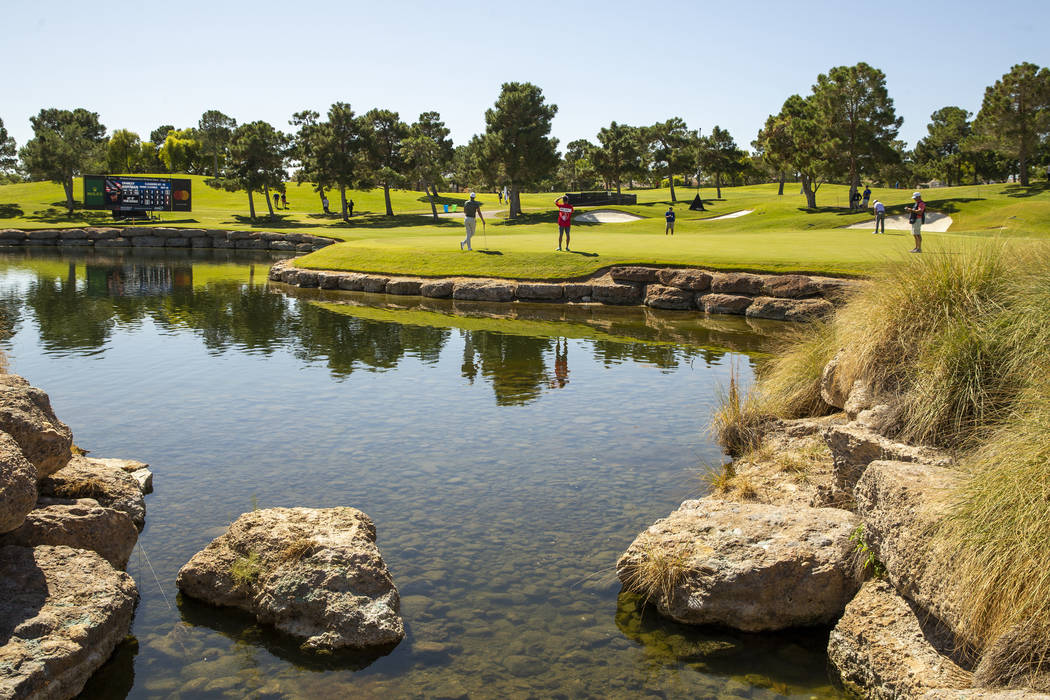 Golfers putt on the 16th green about the water hole during the third round of Shriners Hospital ...