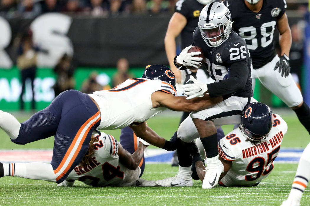 Oakland Raiders running back Josh Jacobs (28) is tackled by Chicago Bears defensive end Roy Rob ...