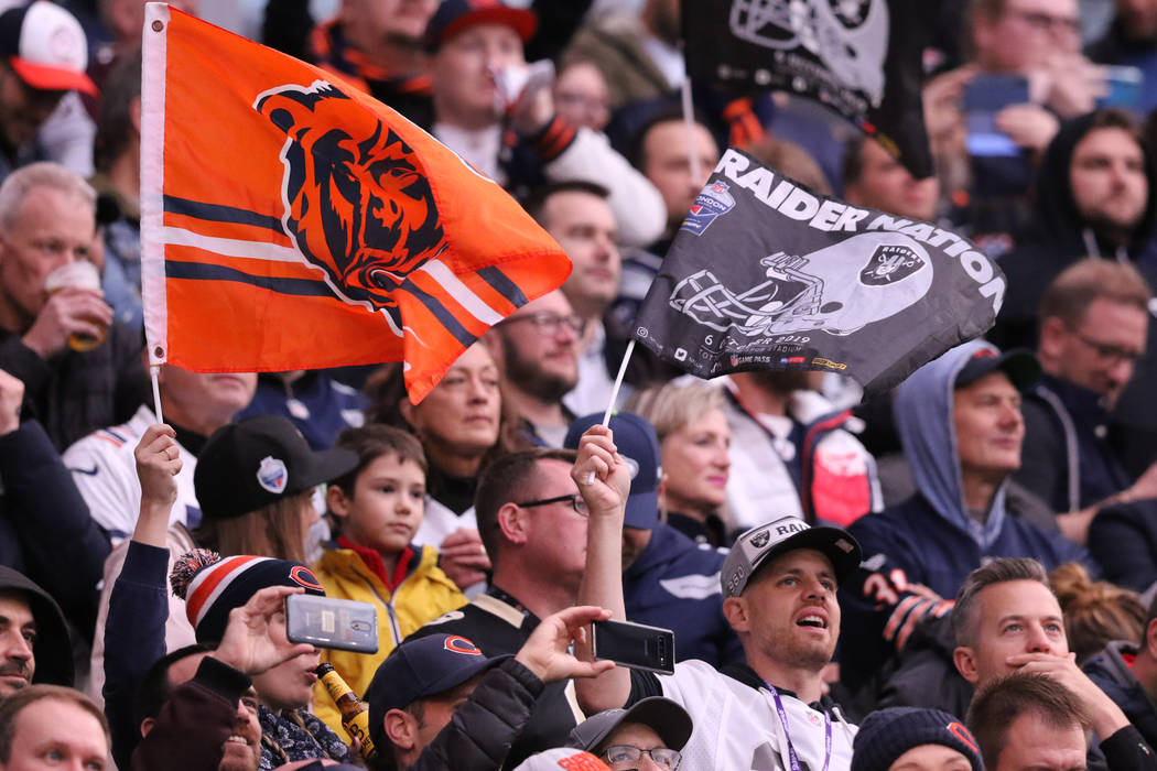 Fans wave team flags at an NFL game between the Oakland Raiders and the Chicago Bears at Totten ...