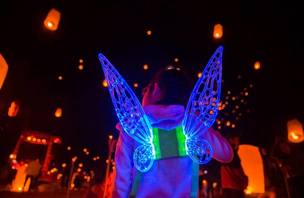 Keira Wang, 5, from Rosemead, Calif., watches lanterns be released during the RiSE festival on ...