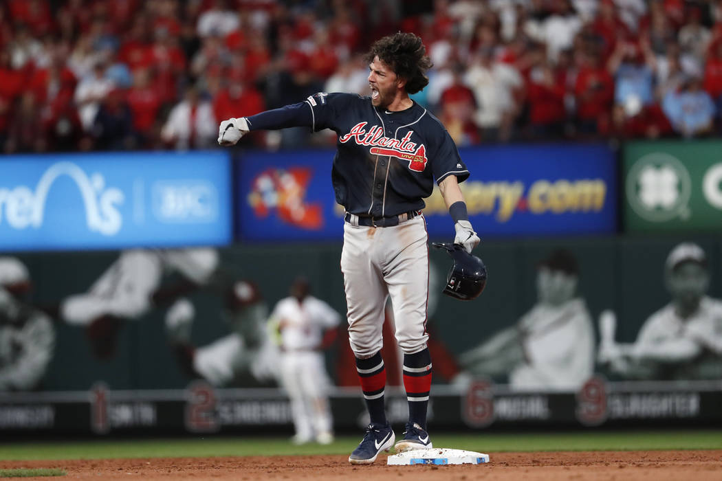 Atlanta Braves' Dansby Swanson celebrates after hitting an RBI-double during the ninth inning i ...
