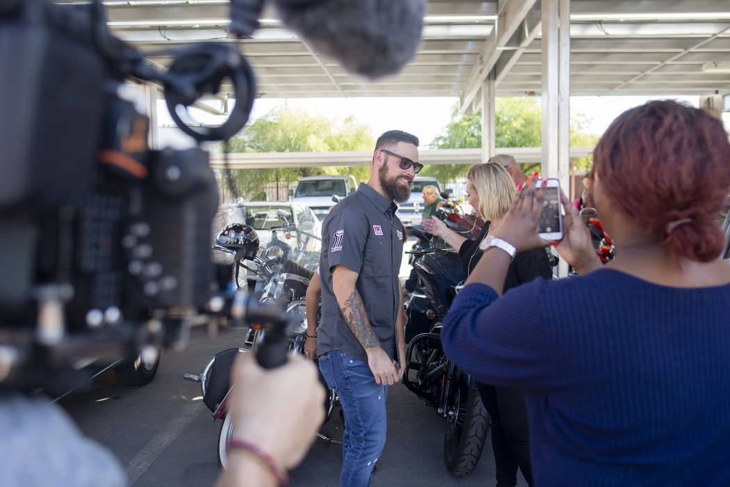 A camera team documents pastor Brandan Thomas from Winchester Rescue Mission in Virginia, left, ...