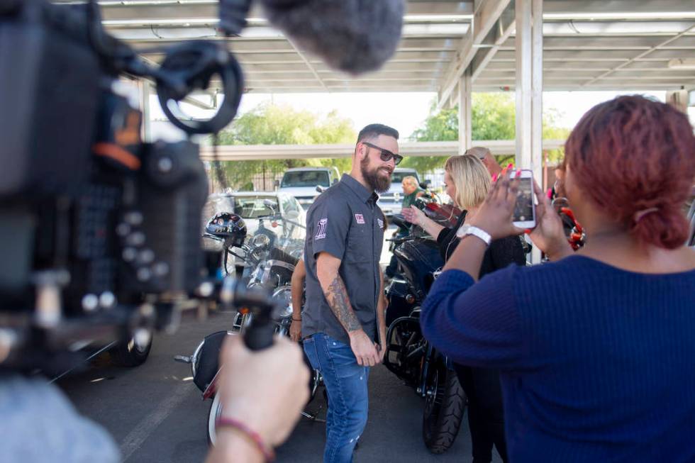 A camera team documents pastor Brandan Thomas from Winchester Rescue Mission in Virginia, left, ...