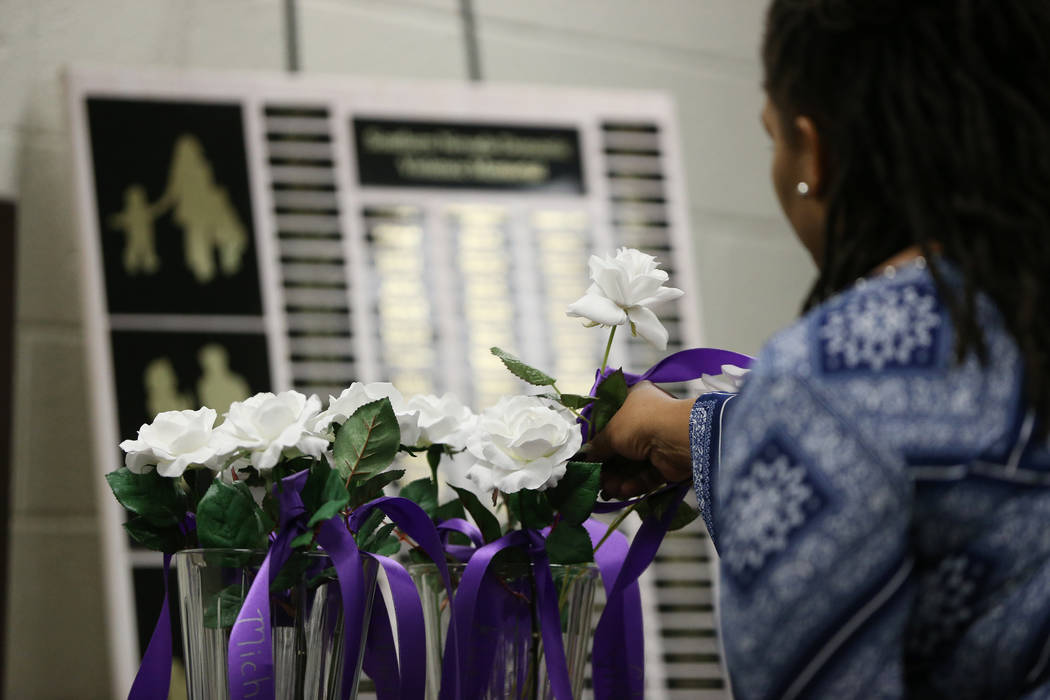 Genese Jones-Torrence,vice president of crisis services at Safe Nest, presents a flower with a ...