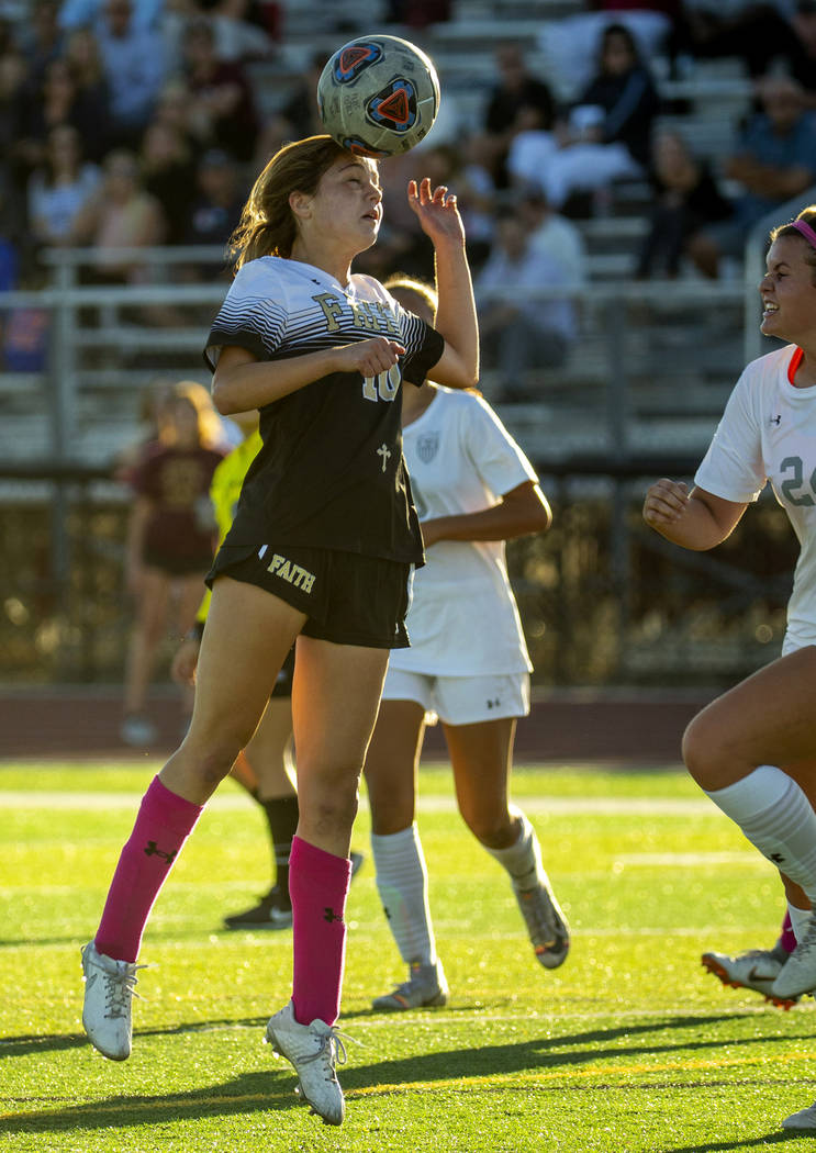 Faith Lutheran's Ari Gronauer (10, left) heads the ball away from Arbor View defenders during t ...