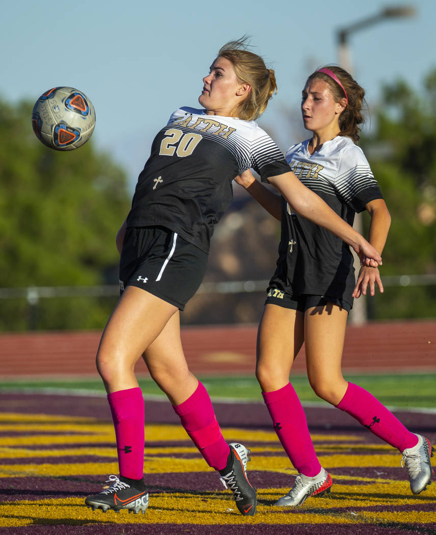 Faith Lutheran's Amelia McManus (20, left) bounces the ball off her midsection and into the Arb ...