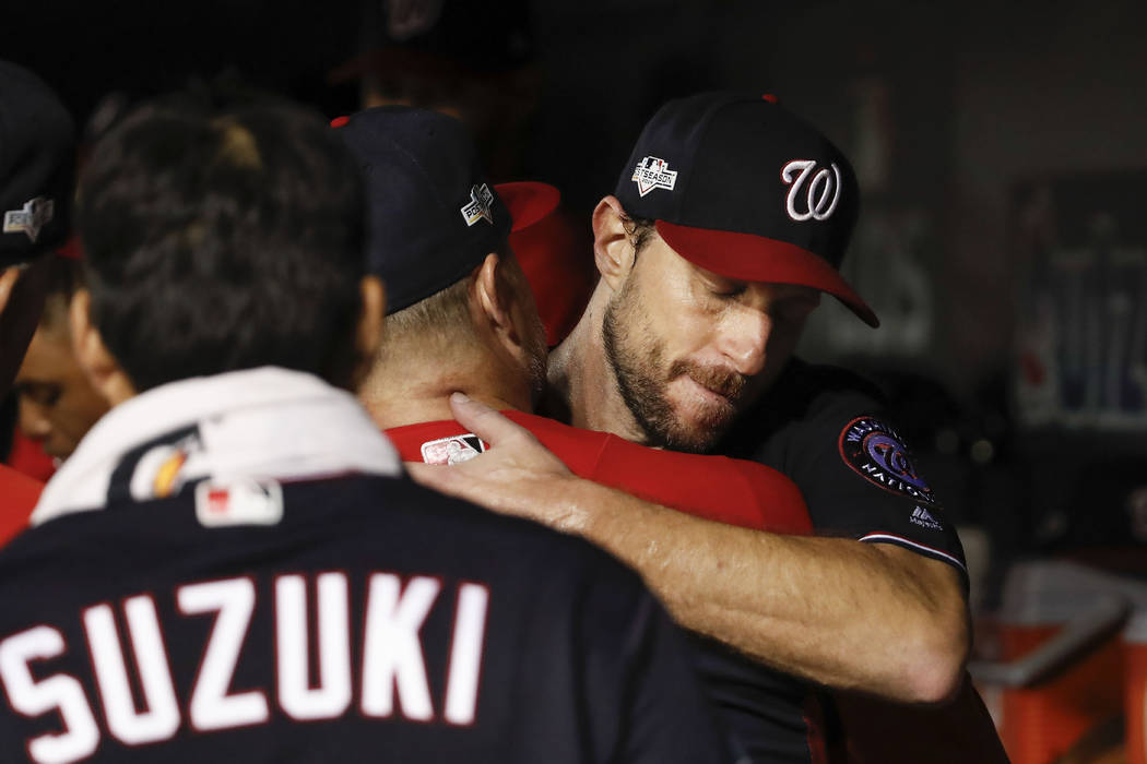 Washington Nationals starting pitcher Max Scherzer (31) is greeted by teammates in the dugout i ...