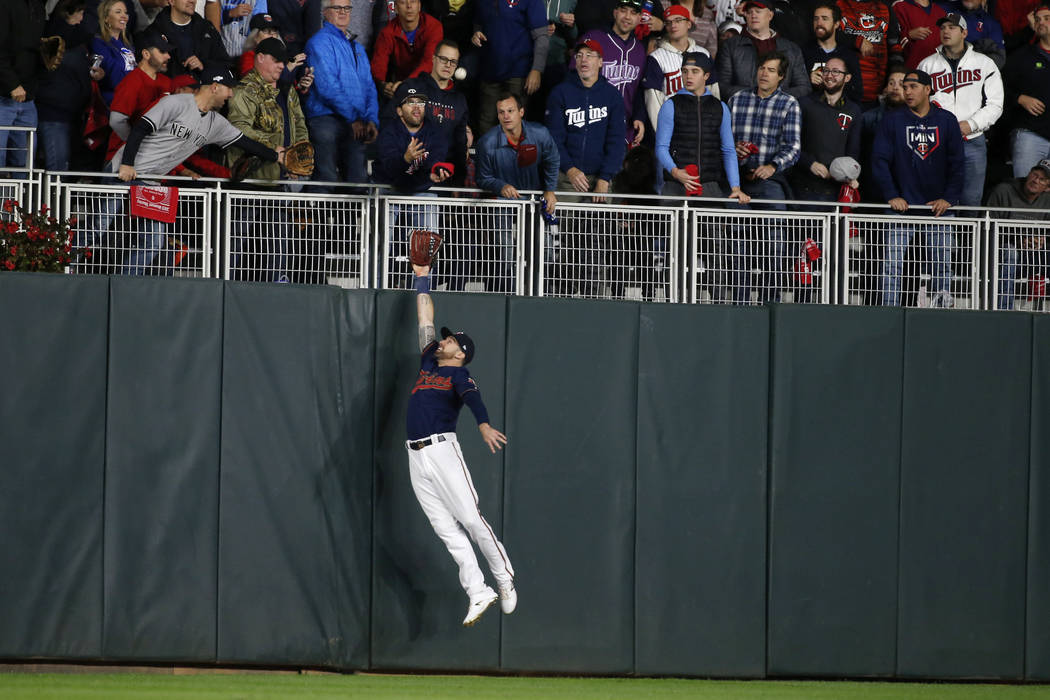 Minnesota Twins left fielder Jake Cave makes a leaping attempt at a home run hit by New York Ya ...