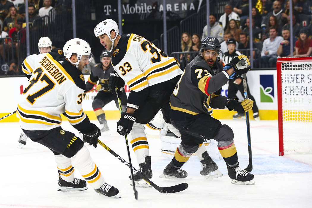 Boston Bruins' Zdeno Chara (33) and Golden Knights' Brandon Pirri (73) look for the puck during ...