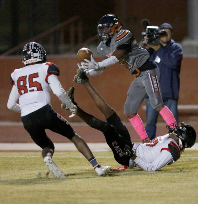 Legacy's Anthony Myles, left, catches a pass as Las Vegas' Flomar Hunt, bottom, falls down dur ...