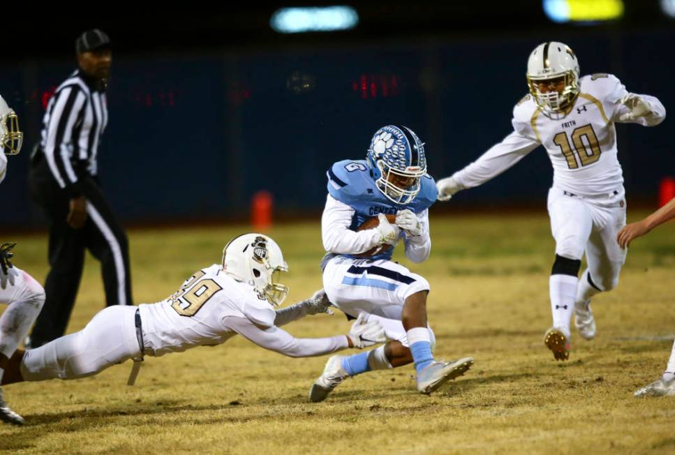 Centennial's Gerick Robinson (6) gets stopped by Faith Lutheran's Jaden Rhodes (39) and Faith L ...