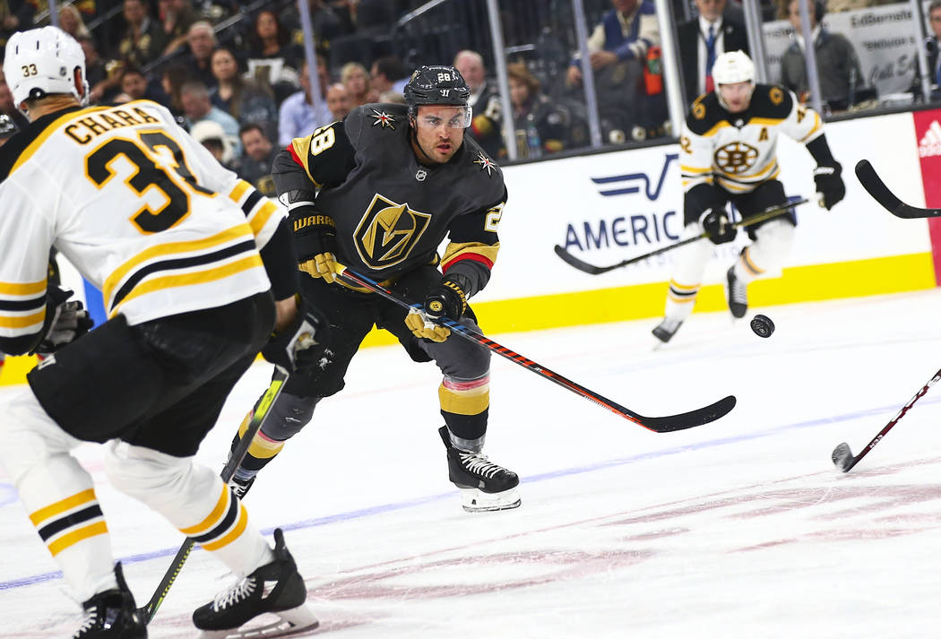 Golden Knights' William Carrier (28) sends the puck past Boston Bruins' Zdeno Chara (33) during ...