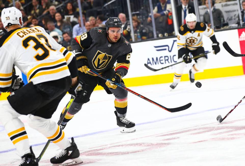 Golden Knights' William Carrier (28) sends the puck past Boston Bruins' Zdeno Chara (33) during ...