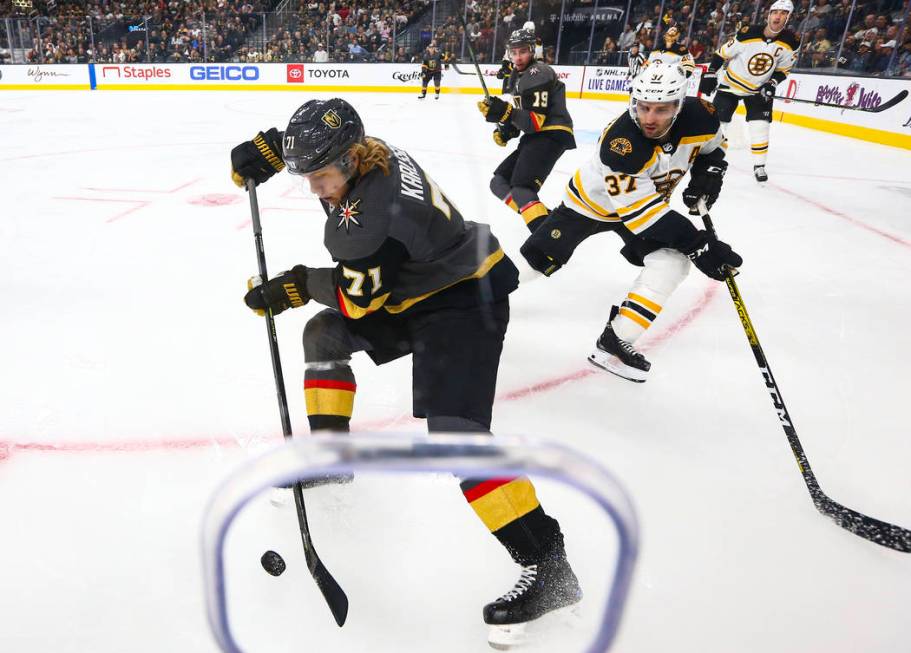 Golden Knights' William Karlsson (71) moves the puck in front of Boston Bruins' Patrice Bergero ...