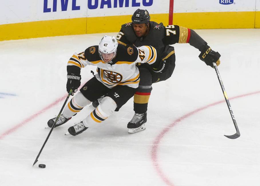 Boston Bruins' Torey Krug (47) skates with the puck under pressure from Golden Knights' Ryan Re ...