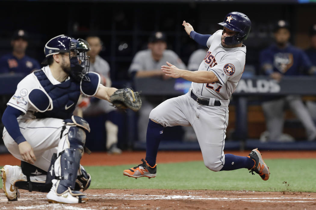 Houston Astros' Jose Altuve, right, heads for home, but is tagged out by Tampa Bay Rays catcher ...
