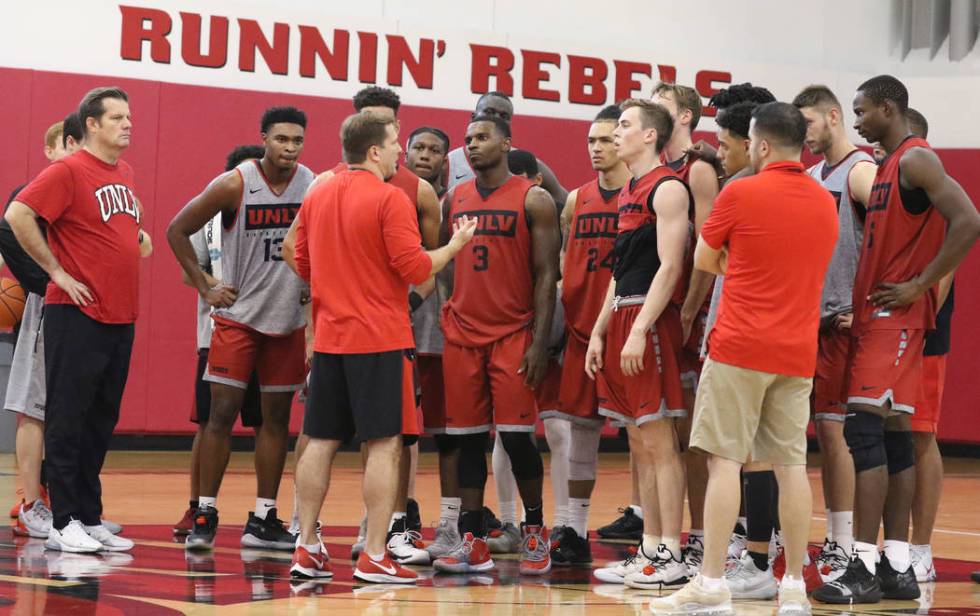 UNLV Rebels head coach T.J. Otzelberger, center, talks to his players after team's first basket ...