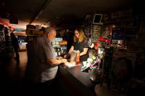 Tom Hyde, left, buys a can of fuel for his Coleman camp stove from Kim Scheffer at a Village Tr ...