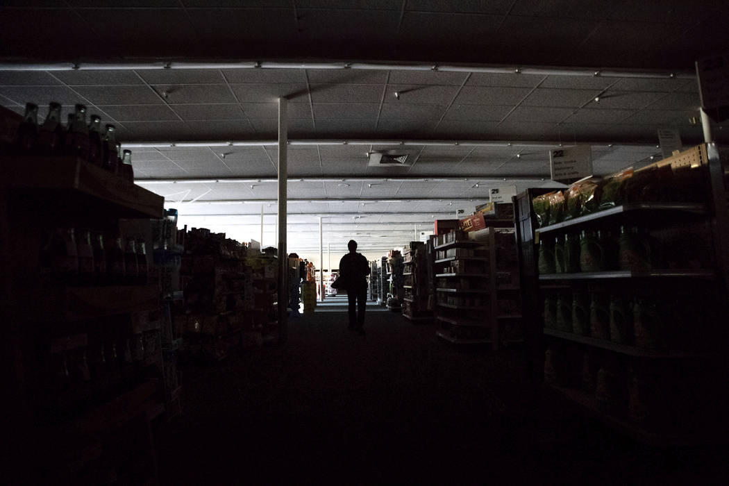 Shift supervisor James Quinn walks through a darkened CVS Pharmacy as downtown Sonoma, Calif., ...