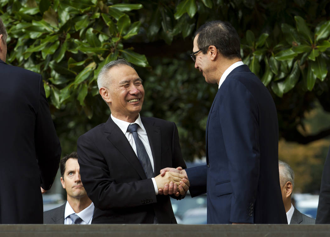 Chinese Vice Premier Liu He shake hands with Treasury Secretary Steven Mnuchin, as he arrives f ...