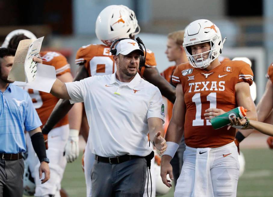 Texas head coach Tom Herman, left, and Texas quarterback Sam Ehlinger (11) during the first hal ...