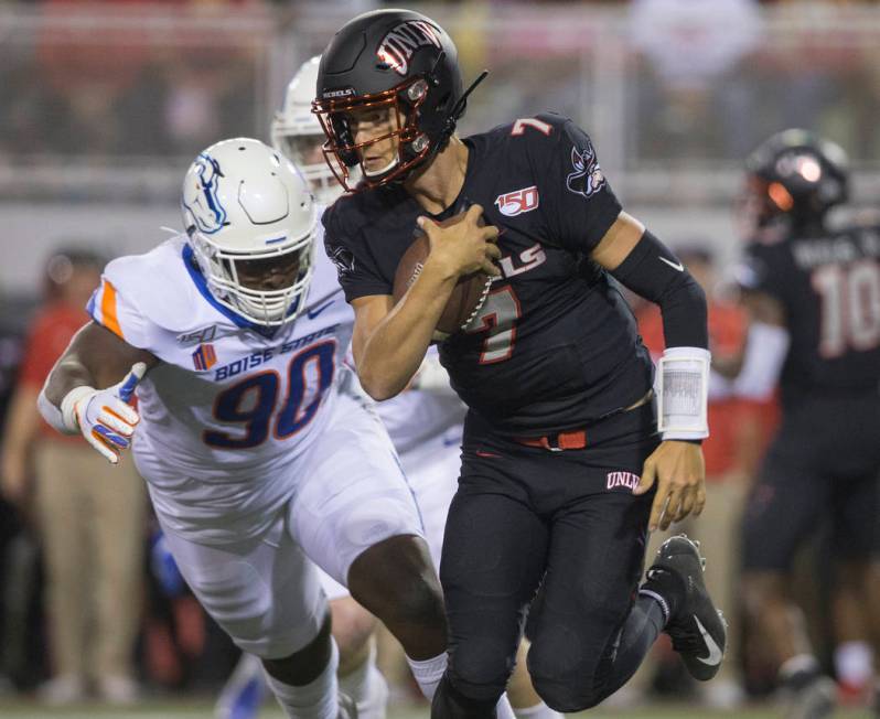 UNLV Rebels quarterback Kenyon Oblad (7) scrambles past Boise State Broncos nose tackle Scale I ...