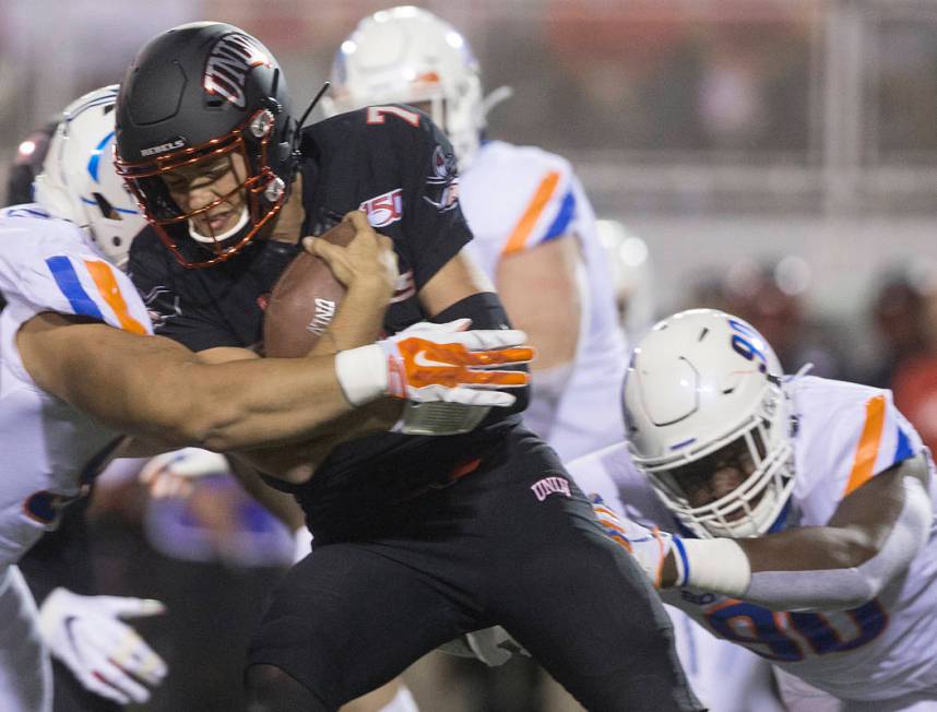 UNLV Rebels quarterback Kenyon Oblad (7) is sandwiched between Boise State defenders in the fir ...