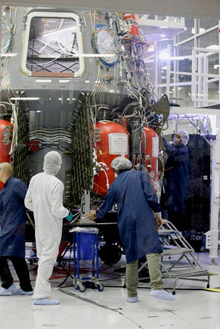 SpaceX employees work on the Crew Dragon spacecraft that will take astronauts to and from the I ...