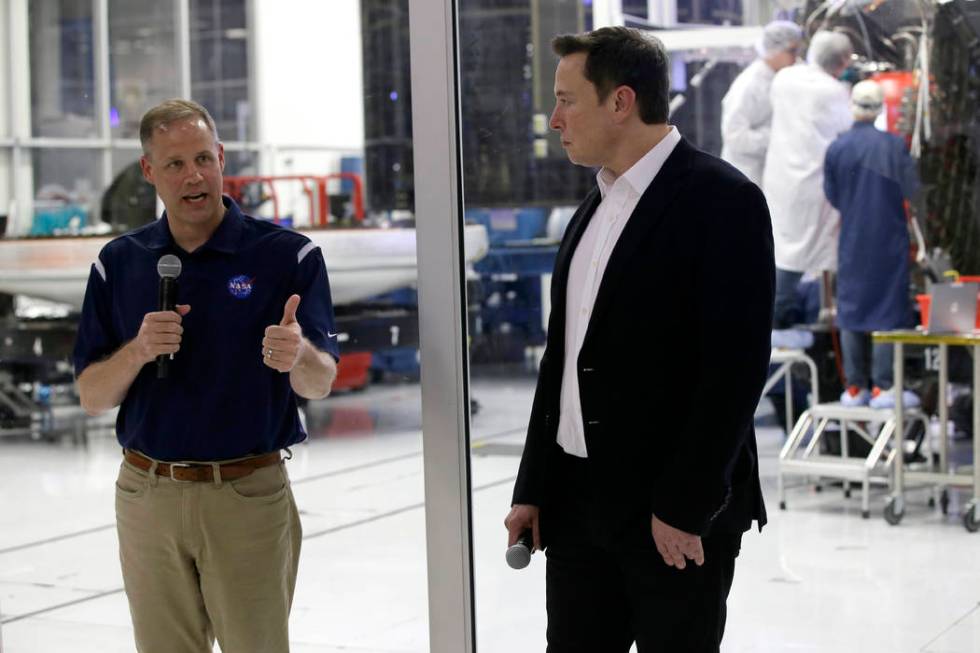 NASA Administrator Jim Bridenstine, left, talks with SpaceX chief engineer Elon Musk, right, in ...