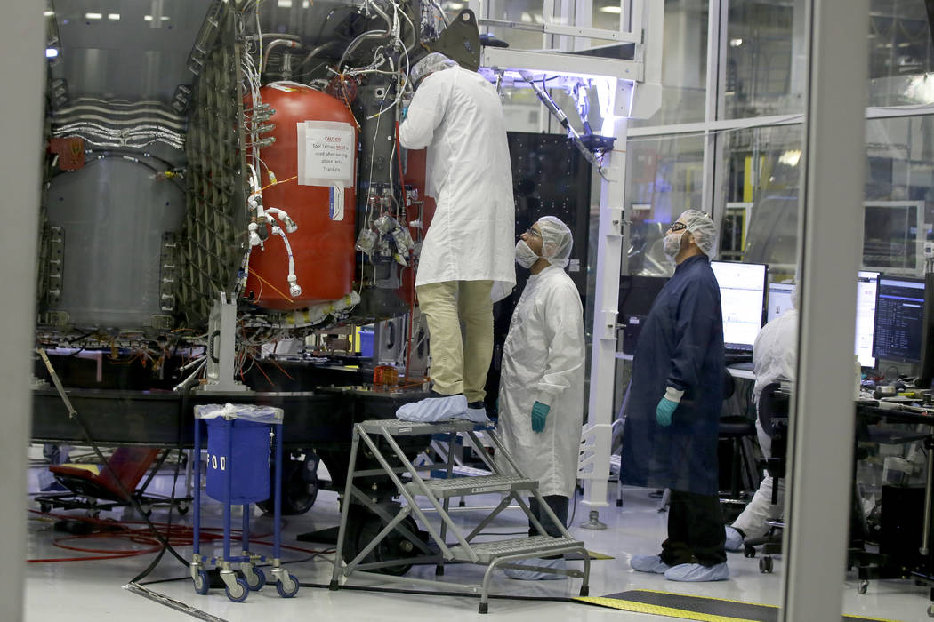 SpaceX employees work on the Crew Dragon spacecraft that will take astronauts to and from the I ...