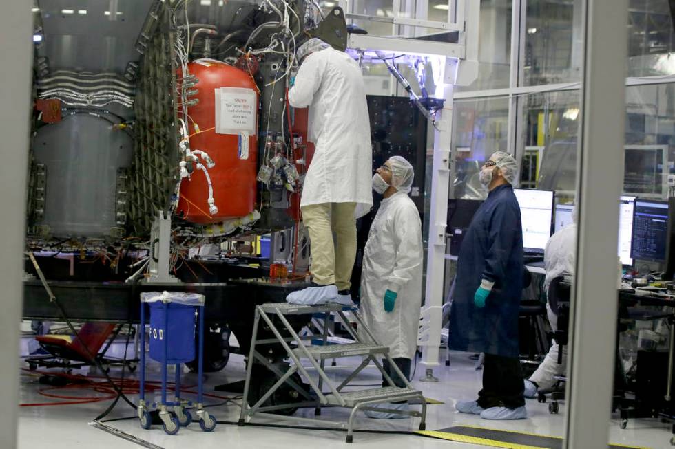 SpaceX employees work on the Crew Dragon spacecraft that will take astronauts to and from the I ...