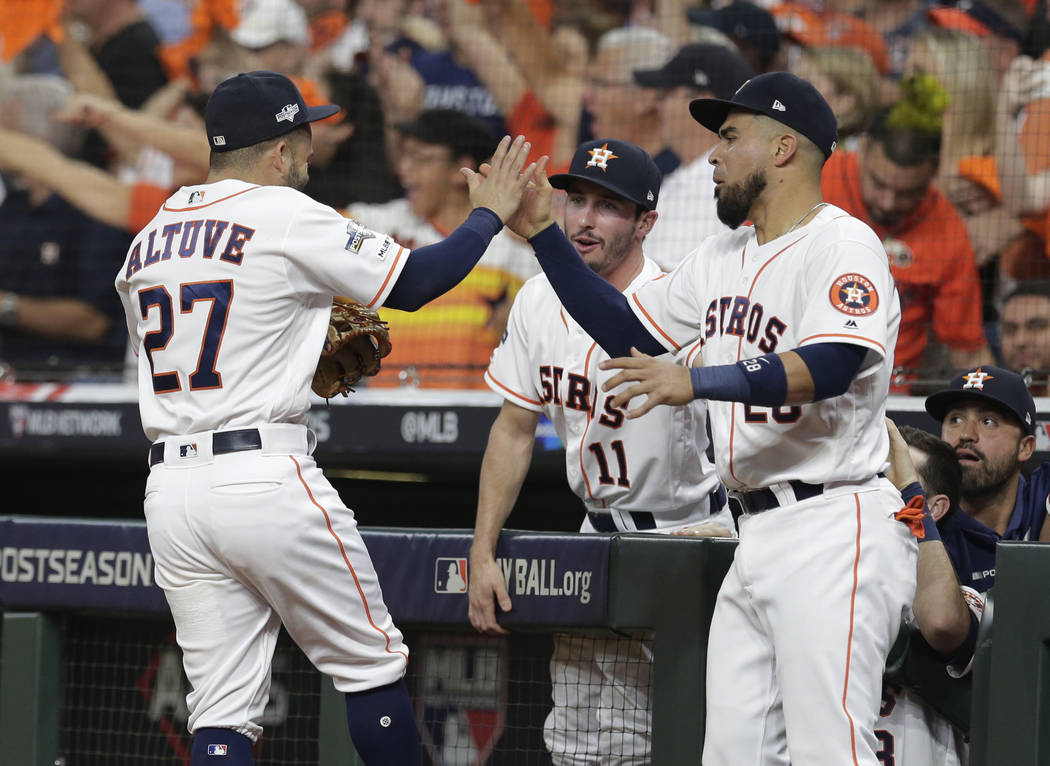 Houston Astros second baseman Jose Altuve (27) celebrates with teammate Robinson Chirinos (28) ...