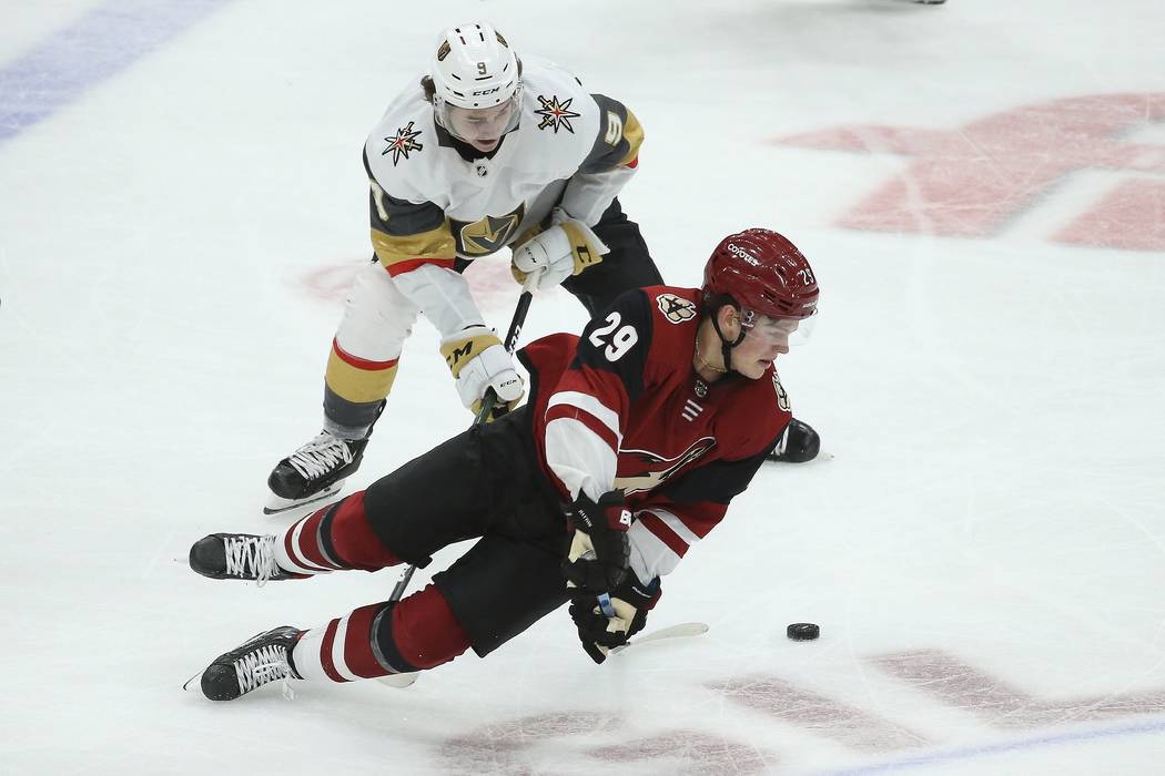 Arizona Coyotes center Barrett Hayton (29) gets tripped by Vegas Golden Knights center Cody Gla ...