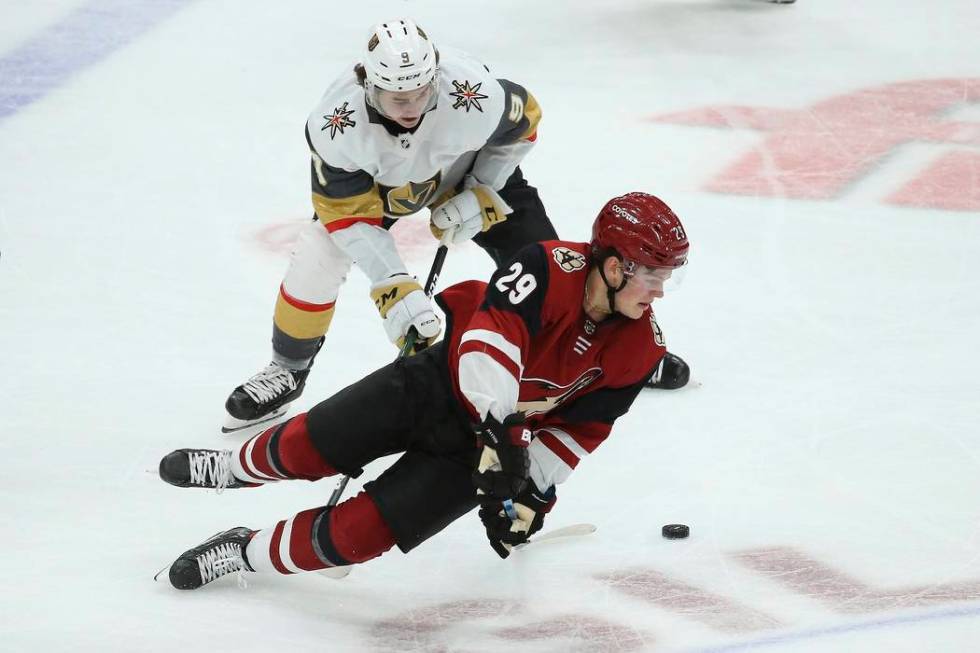 Arizona Coyotes center Barrett Hayton (29) gets tripped by Vegas Golden Knights center Cody Gla ...