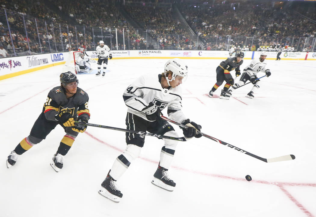 Los Angeles Kings' Tobias Bjornfot (54) skates with the puck ahead of Golden Knights' Cody Eaki ...