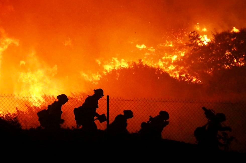 Firefighters battle the Saddleridge fire in Sylmar, Calif., Friday Oct. 11, 2019. (AP Photo/Dav ...