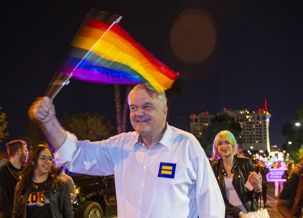 Governor Steve Sisolak waves a flag while marching in the Pride parade on Friday, Oct. 11, 2019 ...