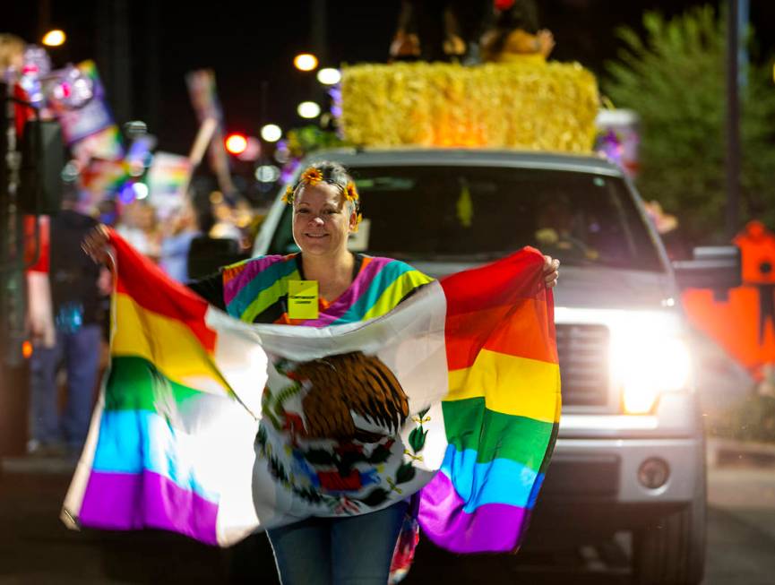 A participant carries a flag while leading her float during the annual Las Vegas Pride Night Pa ...