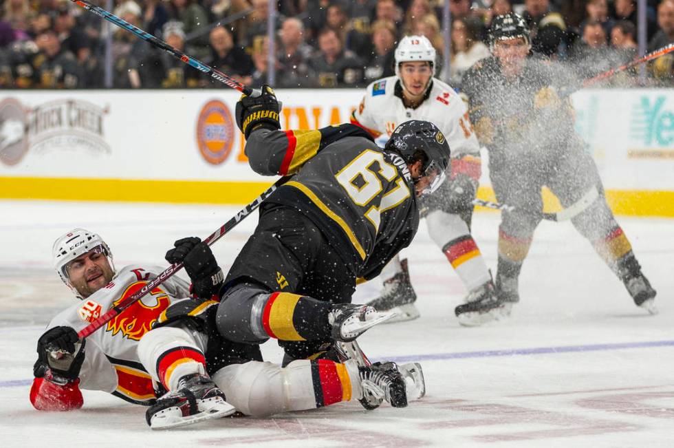 Calgary Flames defenseman Mark Giordano (5, left) takes out Vegas Golden Knights right wing Mar ...