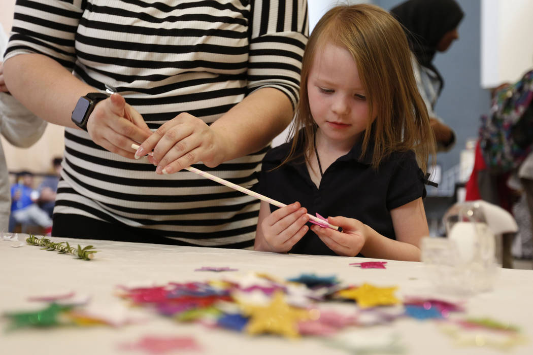 Haylee Applegate, 5, of Las Vegas makes a wand with her mother Ashley Brookins during Mystic Fa ...