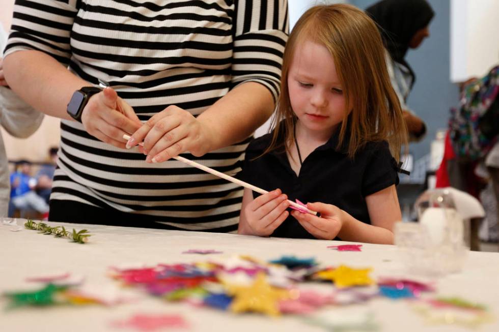 Haylee Applegate, 5, of Las Vegas makes a wand with her mother Ashley Brookins during Mystic Fa ...