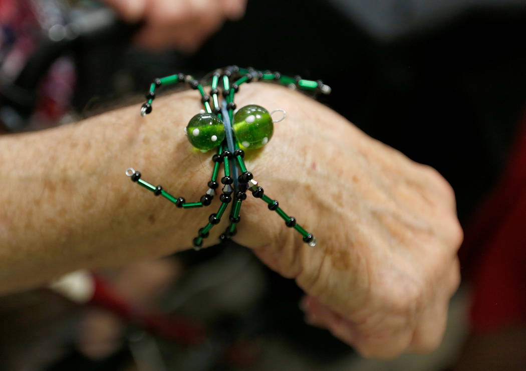 Karen Byrne, 74, of Third Eye Gifts in Las Vegas shows her beaded artwork during Mystic Fair at ...