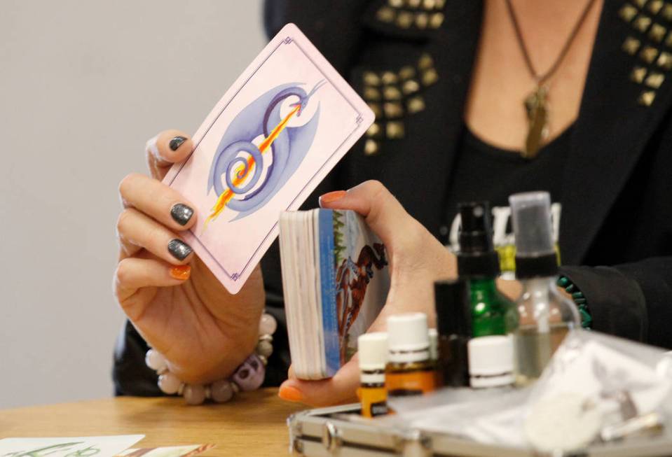 Local psychic Nicole Borghi shows a card during her angel card reading session with her client ...