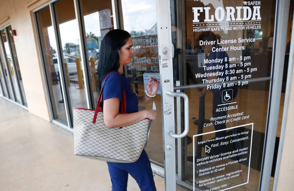 A woman enters a Florida Highway Safety and Motor Vehicles drivers license service center on Tu ...