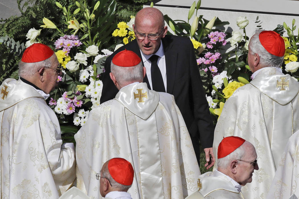 Vatican head of security Domenico Giani, top center, speaks to a group of cardinals during a ca ...