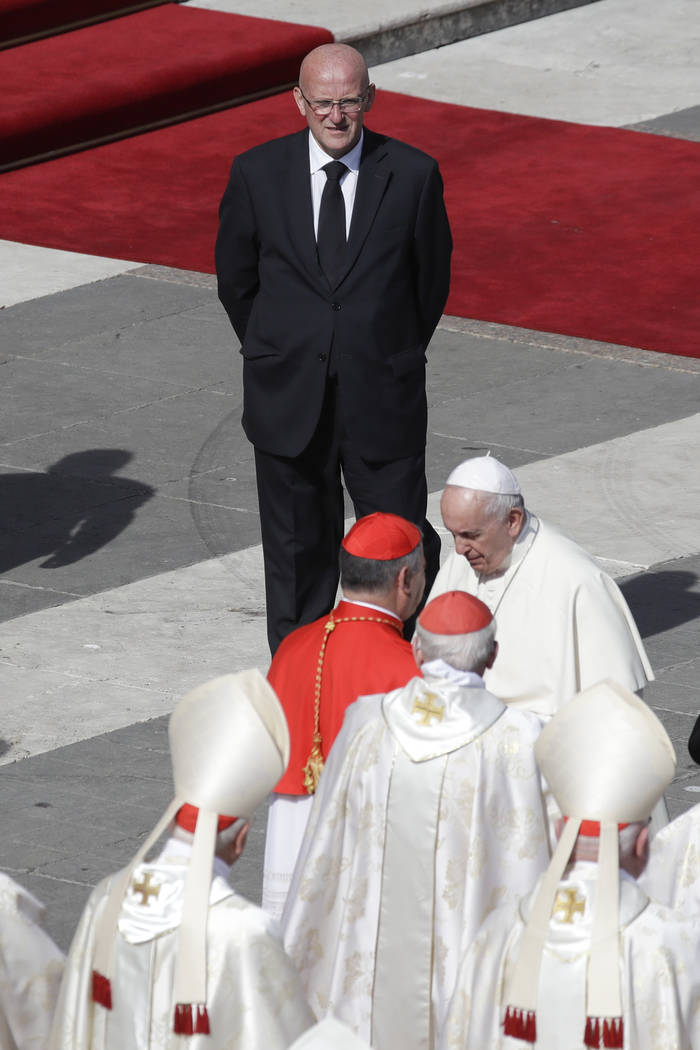 Vatican head of security Domenico Giani, top, looks at Pope Francis at the end of a canonizatio ...