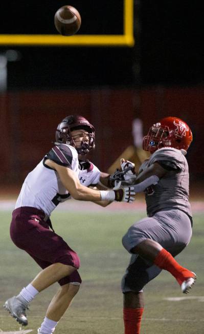 Faith Lutheran senior wide receiver Riley Schwartz (2) fights for a deflected pass with Arbor V ...
