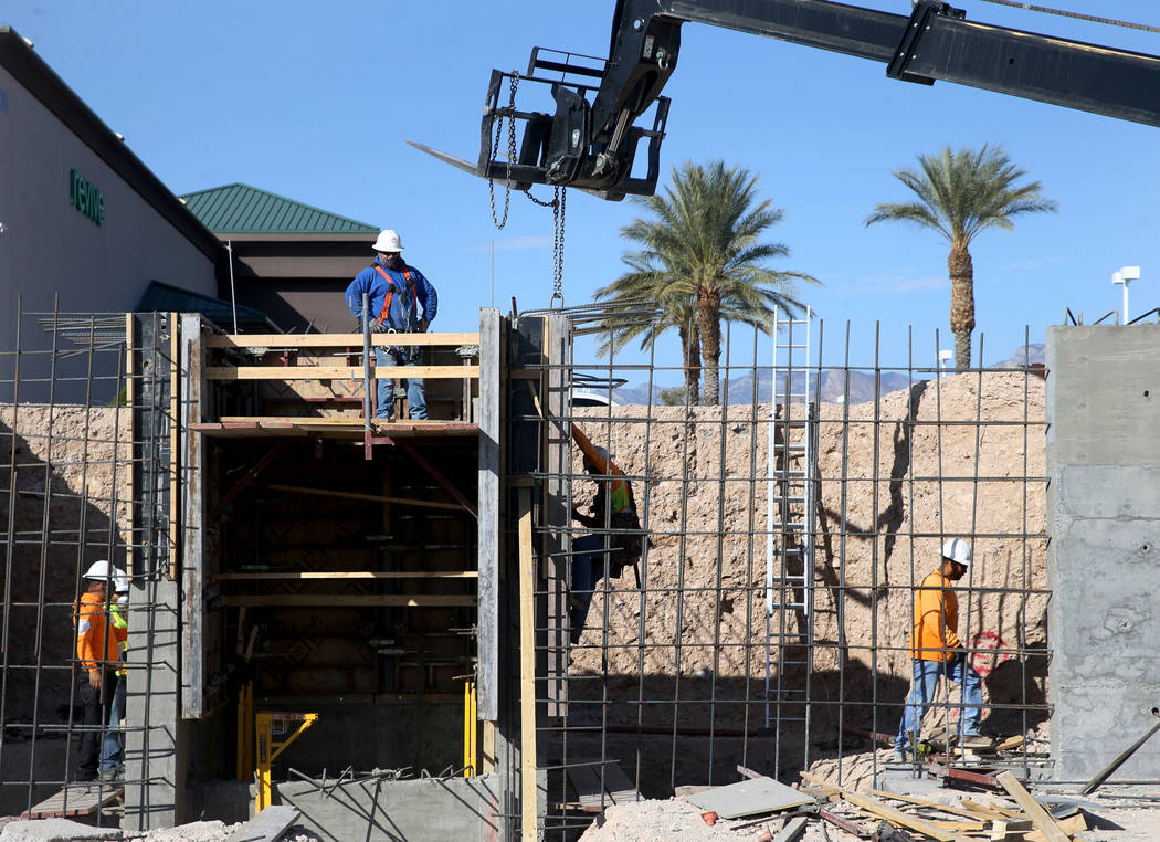 Workers build a retaining wall for a new Calida Group apartment complex at 8791 Alta Drive in L ...